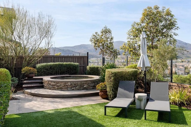 view of yard with a patio, a mountain view, and an outdoor hot tub