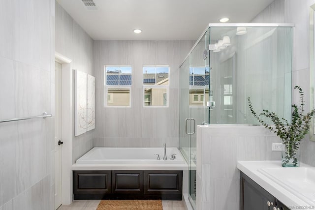 bathroom featuring vanity and plus walk in shower