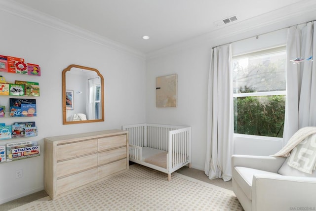 bedroom featuring light carpet, a crib, and ornamental molding