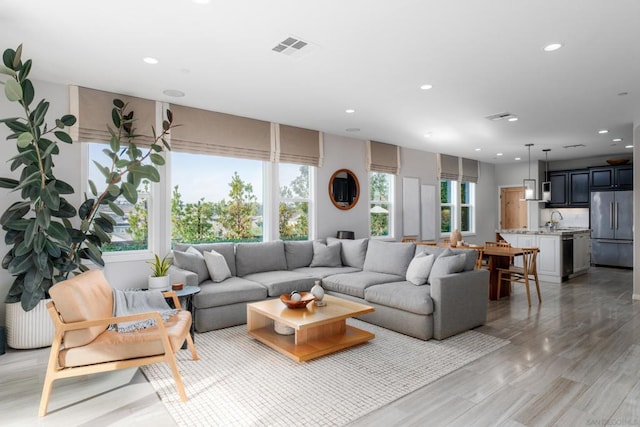 living room featuring sink, hardwood / wood-style flooring, and plenty of natural light