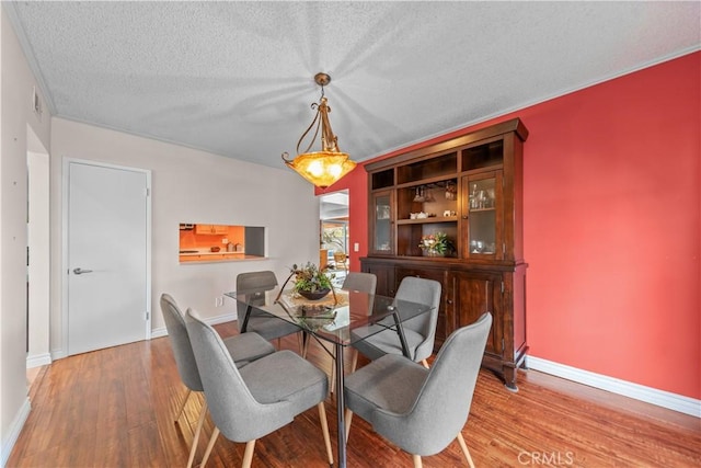 dining room with hardwood / wood-style floors and a textured ceiling