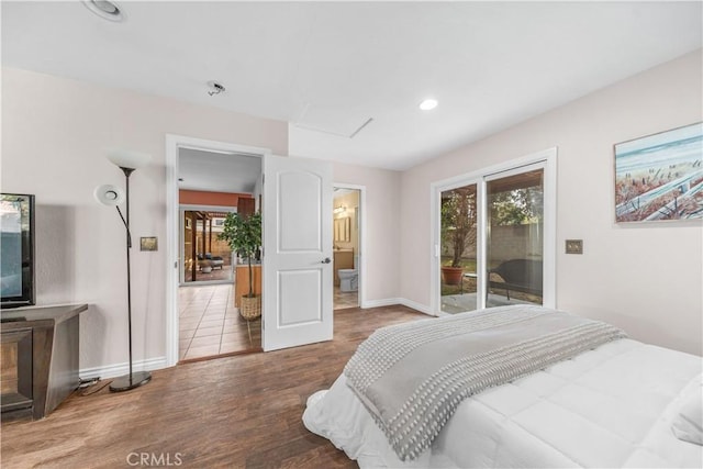 bedroom with multiple windows, wood-type flooring, and access to outside