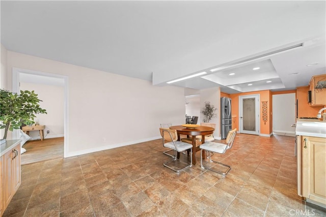 dining room featuring a raised ceiling and sink