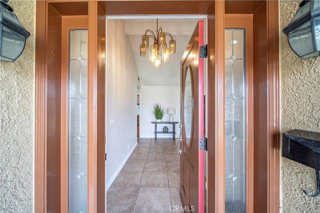 hall with an inviting chandelier and light tile patterned floors