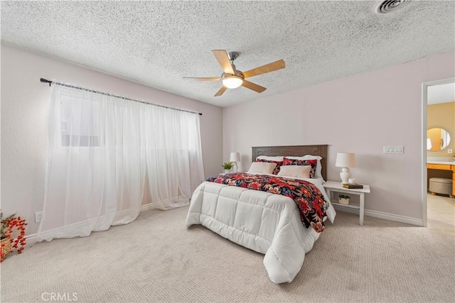 carpeted bedroom featuring ceiling fan and a textured ceiling