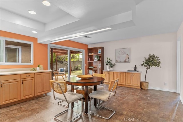 dining space with a raised ceiling