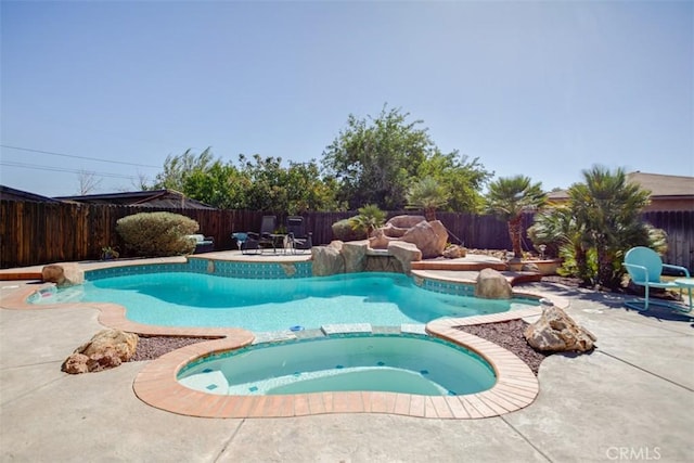 view of swimming pool featuring an in ground hot tub and a patio