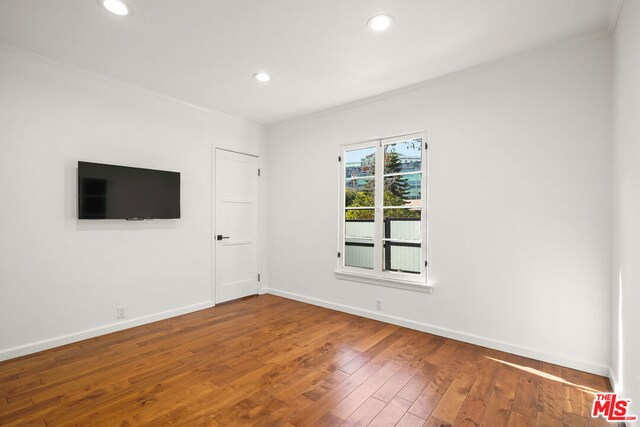 unfurnished room featuring crown molding and wood-type flooring