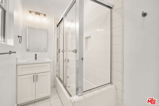 bathroom with enclosed tub / shower combo, vanity, and tile patterned floors