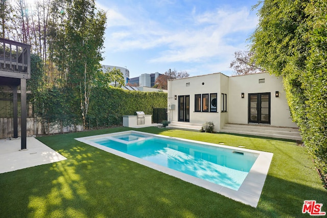 view of pool featuring an outdoor kitchen, a yard, and a patio area