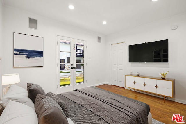 bedroom with hardwood / wood-style floors and french doors