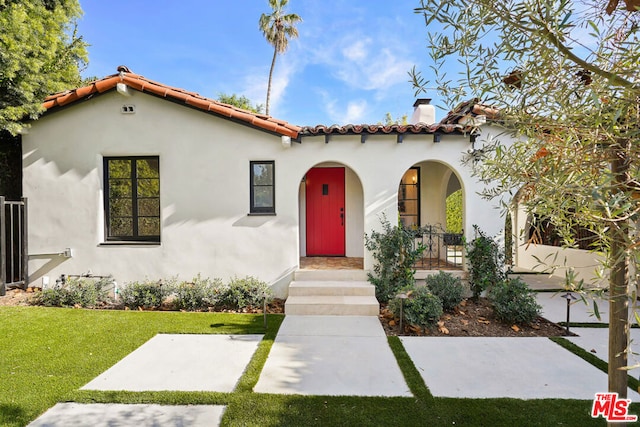 mediterranean / spanish house with a front yard