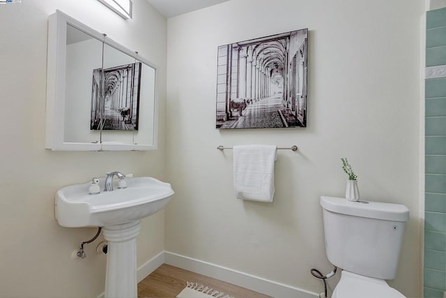 bathroom featuring hardwood / wood-style flooring and toilet