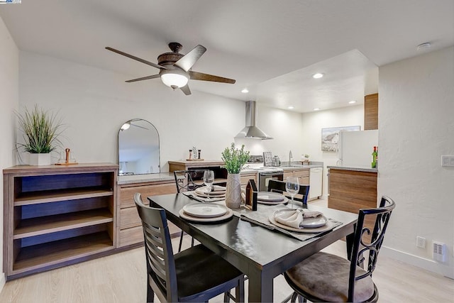 dining space featuring ceiling fan, sink, and light hardwood / wood-style floors