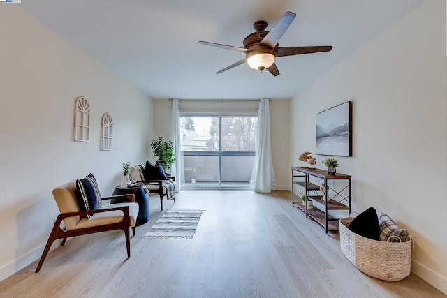 living area featuring light hardwood / wood-style floors and ceiling fan