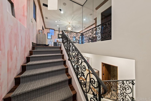 staircase featuring visible vents and a high ceiling