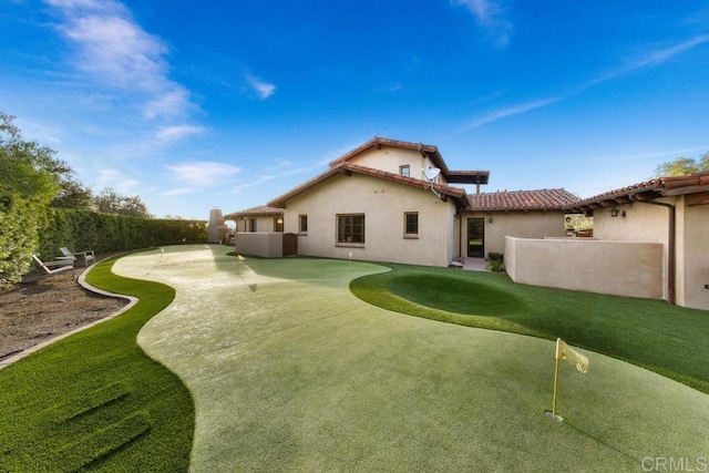 rear view of property featuring a patio area, a tiled roof, fence, and stucco siding