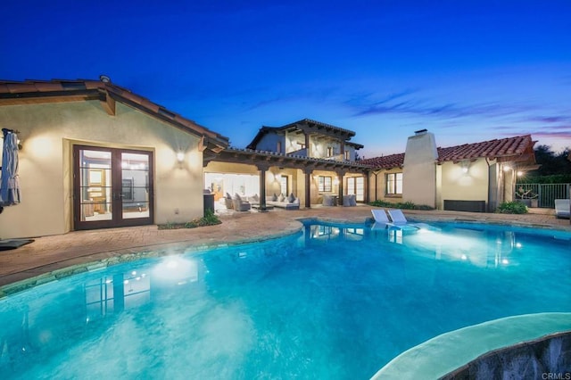 view of swimming pool featuring a patio, french doors, fence, and a fenced in pool