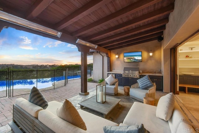 view of patio with a fenced in pool, an outdoor hangout area, a grill, a sink, and exterior kitchen