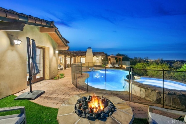 view of pool with a patio, an outdoor fire pit, an in ground hot tub, fence, and a fenced in pool