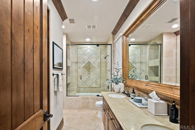 full bathroom with visible vents, tiled shower / bath, toilet, a sink, and double vanity