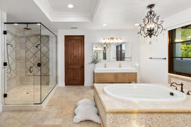 bathroom featuring a bath, a shower stall, a raised ceiling, and crown molding