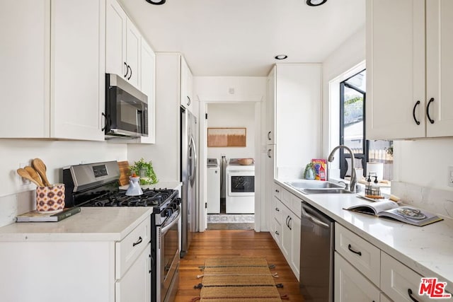 kitchen featuring sink, dark hardwood / wood-style floors, stainless steel appliances, light stone countertops, and white cabinets