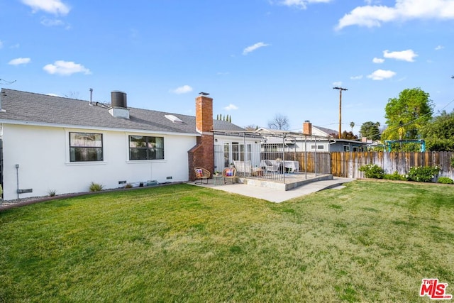 rear view of property with a yard and a patio area