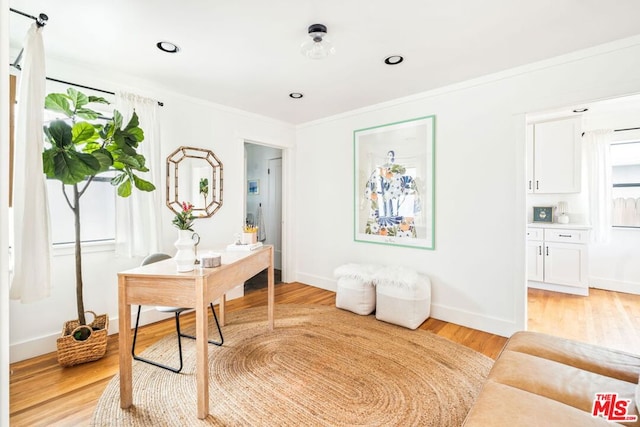 home office featuring crown molding and light hardwood / wood-style floors