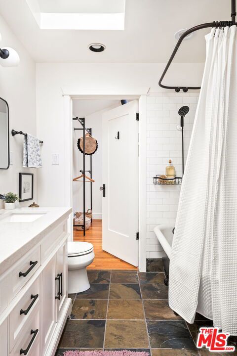 full bathroom featuring vanity, toilet, and shower / tub combo with curtain