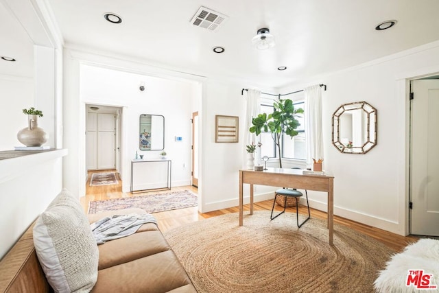 home office with hardwood / wood-style flooring and crown molding