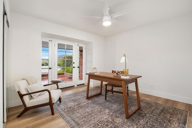 office featuring a ceiling fan, light wood-style flooring, and baseboards