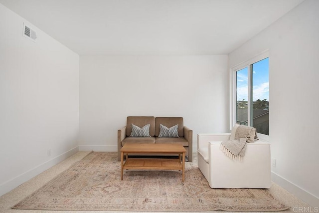 sitting room with carpet flooring, visible vents, and baseboards