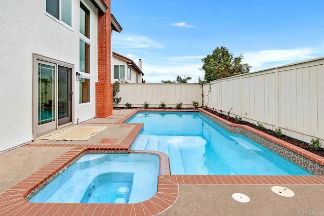 view of pool with a pool with connected hot tub, a fenced backyard, and a patio