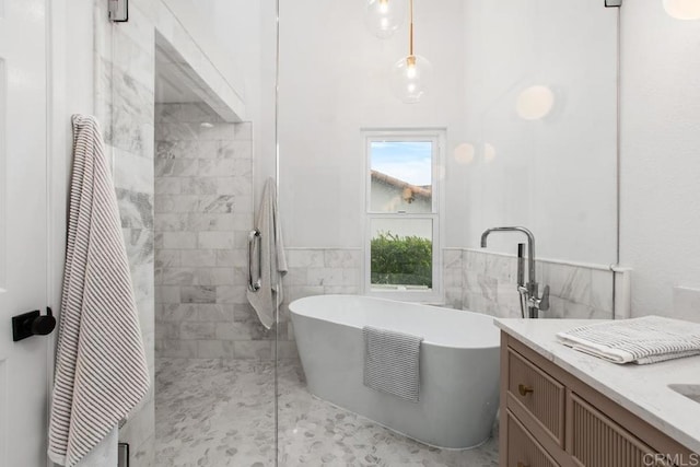 full bath featuring tile walls, a freestanding bath, wainscoting, a tile shower, and vanity