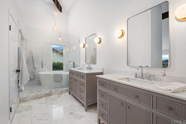 bathroom with marble finish floor, a soaking tub, a sink, and a shower stall