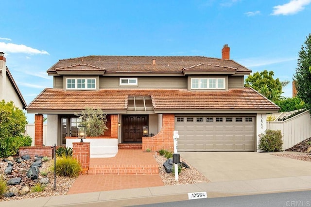 traditional-style house with a garage, brick siding, fence, driveway, and a chimney