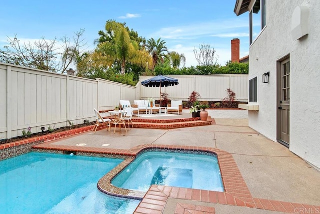 view of pool featuring a patio, a fenced backyard, and a pool with connected hot tub