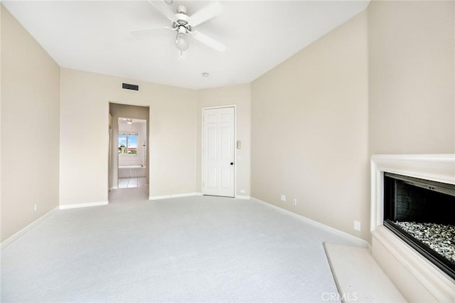 unfurnished living room featuring light colored carpet and ceiling fan