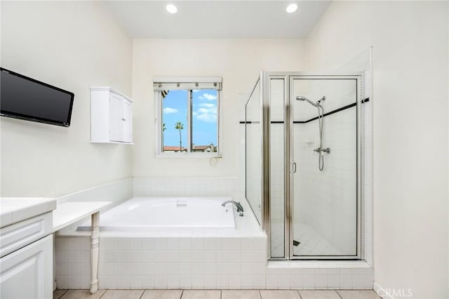 bathroom with vanity and shower with separate bathtub