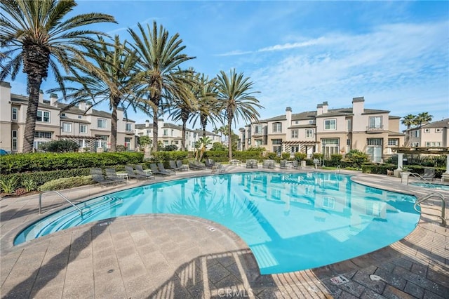 pool with a residential view and a patio