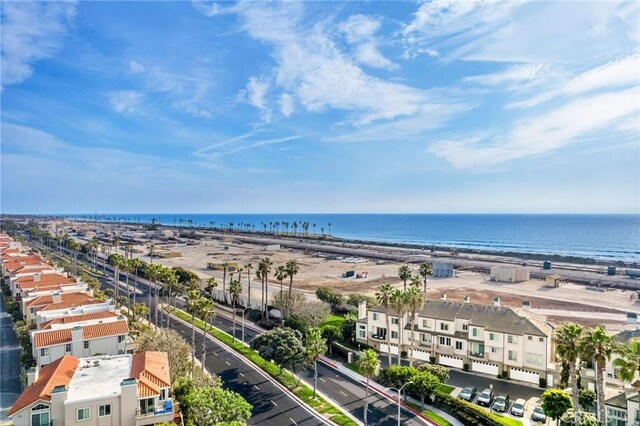 birds eye view of property with a water view and a beach view