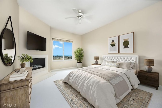 bedroom with carpet floors, a ceiling fan, and a fireplace