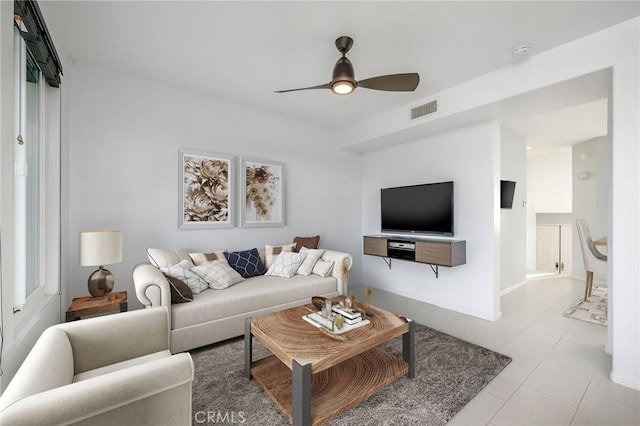 living area with visible vents, baseboards, and ceiling fan