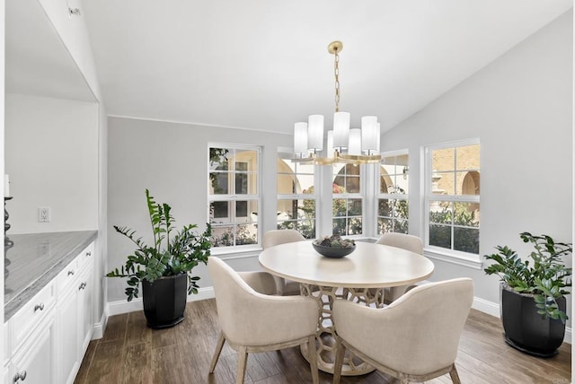 dining room featuring lofted ceiling, hardwood / wood-style floors, and a chandelier