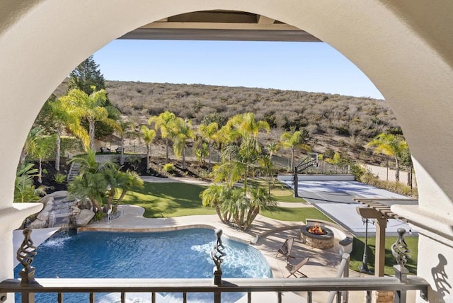 view of swimming pool with an outdoor fire pit, a yard, and a patio area