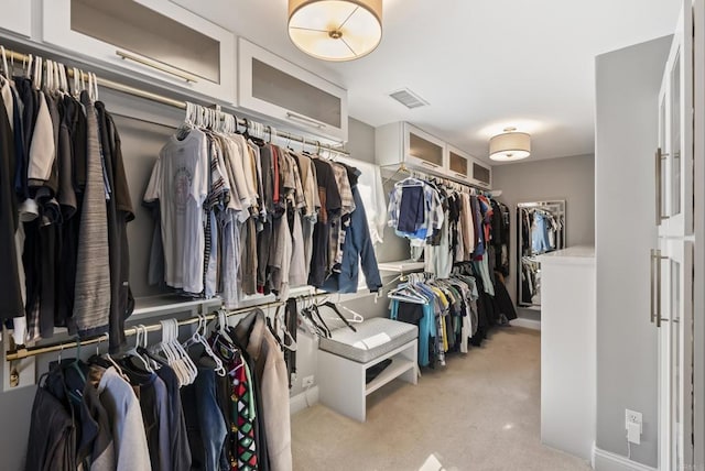 walk in closet featuring light colored carpet