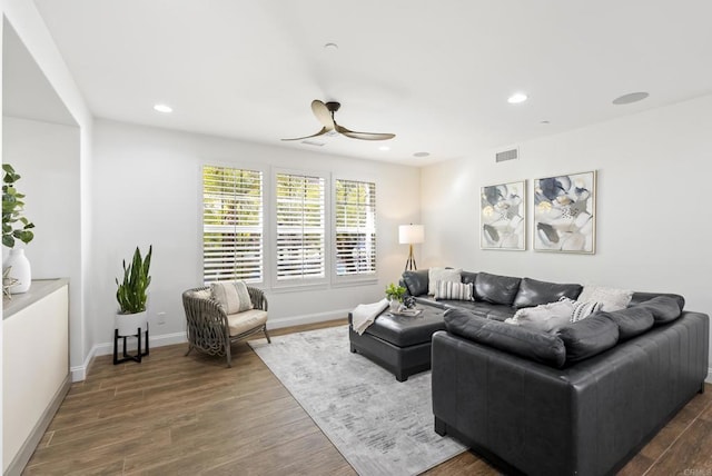 living room with ceiling fan and dark hardwood / wood-style flooring