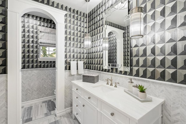 bathroom featuring tile walls, vanity, and toilet