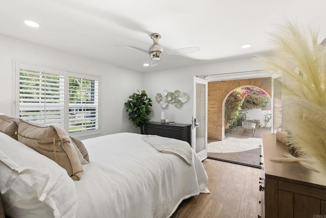 bedroom with hardwood / wood-style floors, ceiling fan, and access to exterior